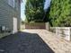 Spacious stone patio perfect for outdoor entertaining, complemented by a fenced yard and charming string lights at 65 N Wilders Ridge Way, Clayton, NC 27527