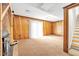 Basement area with wood paneling, fireplace, carpet flooring, and access to the backyard at 6709 Johnsdale Rd, Raleigh, NC 27615