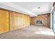 Basement area with wood paneling, fireplace, carpet flooring, and access to the backyard at 6709 Johnsdale Rd, Raleigh, NC 27615