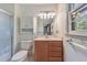 Bathroom with a white toilet, wood vanity, and shower with a glass door at 6709 Johnsdale Rd, Raleigh, NC 27615