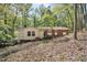 View of a charming single-story home with a brick facade, complemented by lush trees and greenery surrounding the property at 6709 Johnsdale Rd, Raleigh, NC 27615