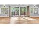 Spacious living room with hardwood floors, large windows, and sliding glass doors to deck at 6709 Johnsdale Rd, Raleigh, NC 27615