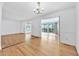 Open-concept living room with wood floors, chandelier, and access to outdoor deck at 6709 Johnsdale Rd, Raleigh, NC 27615