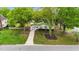 Birds eye view of a cozy single-story home with a pink door, surrounded by mature trees and a green lawn at 703 E Horne St, Clayton, NC 27520