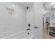 A modern bathroom features a tub, tile shower, and a door leading to an adjacent room, creating a private and relaxing space at 703 E Horne St, Clayton, NC 27520
