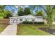 Charming single-story home featuring a pink front door and lush landscaping, creating a welcoming curb appeal at 703 E Horne St, Clayton, NC 27520