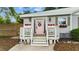 Inviting front porch adorned with flower boxes and potted plants flanking a charming pink front door with glass details at 703 E Horne St, Clayton, NC 27520