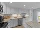 Updated kitchen featuring white cabinets, granite countertops, and subway tile backsplash at 703 E Horne St, Clayton, NC 27520