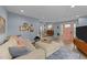 Cozy living room featuring light blue walls, neutral furnishings, wood floors and pink front door at 703 E Horne St, Clayton, NC 27520