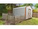 Metal shed with an aged wood frame in a fenced area at 703 E Horne St, Clayton, NC 27520