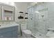 Modern bathroom boasts sleek glass shower, marble details, vanity, and floating shelves, offering a luxurious experience at 714 Mordecai Towne Pl, Raleigh, NC 27604
