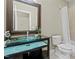 This bathroom showcases a floating glass sink, dark wood cabinet, a toilet and a shower/tub with tile surround at 714 Mordecai Towne Pl, Raleigh, NC 27604