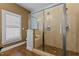Modern bathroom featuring a glass-enclosed shower, tiled walls, and a window for natural light at 714 Mordecai Towne Pl, Raleigh, NC 27604