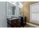 This bathroom features double sinks with a large mirror and elegant lighting fixtures above the dark wood cabinets at 714 Mordecai Towne Pl, Raleigh, NC 27604
