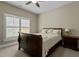 Cozy bedroom with a wooden sleigh bed, a floral pillow, bedside table, and plantation shutters letting in plenty of natural light at 714 Mordecai Towne Pl, Raleigh, NC 27604