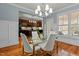 Bright dining room featuring a glass table, modern lighting, and a view into the updated kitchen at 714 Mordecai Towne Pl, Raleigh, NC 27604