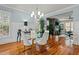 Bright dining room featuring hardwood floors, a glass table with seating, and natural light from large windows at 714 Mordecai Towne Pl, Raleigh, NC 27604