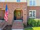 Inviting brick entryway with arched doorway, featuring a charming wooden door and a welcoming American flag at 714 Mordecai Towne Pl, Raleigh, NC 27604