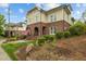 Inviting exterior of a home with a brick facade, arched entryway, and well-manicured landscaping at 714 Mordecai Towne Pl, Raleigh, NC 27604