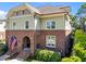 Beautiful townhome showcases classic brickwork, complemented by tan shingles and an inviting arched entrance, topped with an American flag at 714 Mordecai Towne Pl, Raleigh, NC 27604