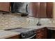 Beautiful kitchen featuring an island, granite countertops, sleek appliances, and a tiled backsplash at 714 Mordecai Towne Pl, Raleigh, NC 27604