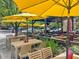 An outdoor patio area with several yellow umbrellas provides shade over a variety of tables and chairs at 714 Mordecai Towne Pl, Raleigh, NC 27604