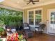Cozy covered patio with comfortable wicker furniture, adorned with vibrant flowers and plants, perfect for relaxation at 714 Mordecai Towne Pl, Raleigh, NC 27604