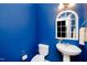 Stylish half bathroom with a modern sink, decorative mirror, and vibrant blue walls at 746 Wickham Ridge Rd, Apex, NC 27539