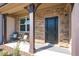Inviting front door with a stone facade, covered entrance, and stylish welcome mat at 746 Wickham Ridge Rd, Apex, NC 27539