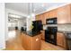 Well-equipped kitchen with an island, black appliances, and hardwood floors at 746 Wickham Ridge Rd, Apex, NC 27539