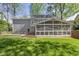 Backyard featuring an enclosed screened in porch and wooden deck, overlooking well-maintained grassy yard at 7705 Glenharden Dr, Raleigh, NC 27613
