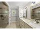 Bright bathroom with double vanity, granite countertop, and walk-in shower with tile at 7705 Glenharden Dr, Raleigh, NC 27613