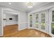 Bright breakfast nook with French doors to deck and hardwood floors connecting to living room at 7705 Glenharden Dr, Raleigh, NC 27613