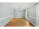 Bright dining room featuring hardwood floors, wainscoting, chandelier, and natural light at 7705 Glenharden Dr, Raleigh, NC 27613