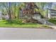 Landscaped front yard showcasing a gray home with a driveway and lush green grass at 7705 Glenharden Dr, Raleigh, NC 27613
