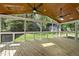 Relaxing screened-in porch with wood ceiling, skylights, ceiling fans, and view of the backyard at 7705 Glenharden Dr, Raleigh, NC 27613