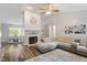 Open-concept living area with a fireplace, ceiling fan, and hardwood floors, perfect for modern living at 807 Clean View Ct, Fuquay Varina, NC 27526