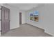 Bright bedroom featuring neutral carpet, a window overlooking the neighborhood, and a stylish door at 858 Lake Artesia Ln, Fuquay Varina, NC 27526