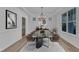This dining room features modern decor, including a chandelier, stylish table and chairs, and a large window at 858 Lake Artesia Ln, Fuquay Varina, NC 27526