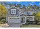 Charming two-story home boasts a well-manicured lawn, two-car garage, and inviting front porch at 858 Lake Artesia Ln, Fuquay Varina, NC 27526