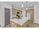 A kitchen features wooden cabinets, stainless steel appliances, an island with white countertop and modern light fixtures at 858 Lake Artesia Ln, Fuquay Varina, NC 27526