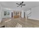 Spacious living room with a ceiling fan, hardwood floors, and natural light streaming through large windows at 858 Lake Artesia Ln, Fuquay Varina, NC 27526