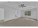 Main bedroom featuring trey ceiling, ceiling fan, neutral carpet, and an ensuite bathroom at 858 Lake Artesia Ln, Fuquay Varina, NC 27526