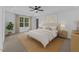 Relaxing main bedroom featuring tray ceiling, large window, and neutral decor at 858 Lake Artesia Ln, Fuquay Varina, NC 27526