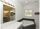 Bright bathroom with a corner soaking tub, white vanity, and window with natural light at 90 Pump Station Rd, Erwin, NC 28339