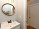 Bathroom with round wooden mirror, white vanity, and door leading to another room at 90 Pump Station Rd, Erwin, NC 28339