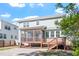 Rear view of home and patio with a screened porch, wooden stairs, and tasteful landscaping at 905 Moye Dr, Raleigh, NC 27606