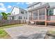 Backyard view displaying the home's screened-in porch, brick patio, and neighboring properties at 905 Moye Dr, Raleigh, NC 27606