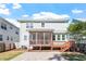 Exterior home view with a screened porch, brick patio, grassy lawn and stairs that lead to the back door at 905 Moye Dr, Raleigh, NC 27606