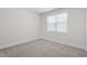 A clean and bright bedroom features neutral paint and carpet, plus a window letting in lots of light at 905 Moye Dr, Raleigh, NC 27606